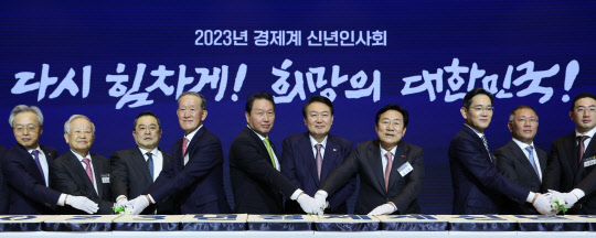 윤석열 대통령이 2일 서울 강남구 코엑스에서 열린 2023 경제계 신년인사회에서 참석자들과 떡을 자르고 있다. 연합뉴스
